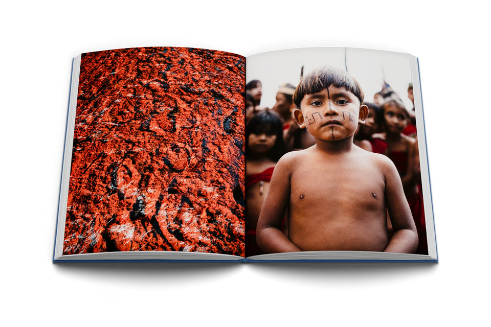 Libro abierto con una textura roja y el retrato de un niño indígena